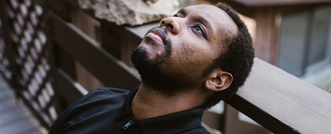 Man leaning back staring into space